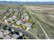 Expansive aerial view showcasing the neighborhood, the nearby walking path and mountains in the distance at 1909 Alpine Dr, Erie, CO 80516