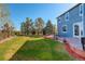 Green backyard with a patio, lush lawn, mature trees, and backyard fence at 1909 Alpine Dr, Erie, CO 80516