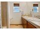 Bright bathroom with double sinks, window and shower with neutral tile features at 1909 Alpine Dr, Erie, CO 80516