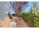 Landscaped side yard featuring a walkway, decorative rocks, and lush greenery at 1909 Alpine Dr, Erie, CO 80516