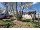 The backyard is spacious with a brick patio, shed, and mature trees at 1720 Pecos Way, Denver, CO 80221