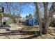 This backyard includes a brick patio, partial overhang, shed, and mature trees at 1720 Pecos Way, Denver, CO 80221