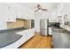 Bright kitchen with stainless steel appliances, white cabinets, and wood floor at 1720 Pecos Way, Denver, CO 80221