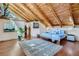 Cozy bedroom with exposed wood beams, hardwood floors, and a large window for natural light at 1928 S Washington St, Denver, CO 80210