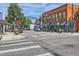 Vibrant street with brick buildings, striped awnings, pedestrian crosswalks, and lush planters for inviting atmosphere at 1928 S Washington St, Denver, CO 80210