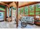 Bright sunroom featuring wood beams, large windows overlooking mature trees, and comfortable seating at 1928 S Washington St, Denver, CO 80210