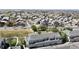 An aerial view shows a neighborhood of townhomes with attached garages, landscaping, and access to community spaces at 9758 Laredo St # 22D, Commerce City, CO 80022