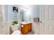 Stylish bathroom featuring a wood vanity, toilet with plant, and a white door at 9758 Laredo St # 22D, Commerce City, CO 80022