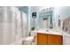 Charming, updated bathroom with blue walls, wood vanity, patterned shower curtain and stylish decor at 9758 Laredo St # 22D, Commerce City, CO 80022