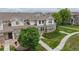 View of this property features a well-manicured lawn, a sidewalk, and a house with stone accents at 9758 Laredo St # 22D, Commerce City, CO 80022