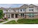 Attractive townhome exterior with manicured lawn, stone accents, and cozy covered entryway at 9758 Laredo St # 22D, Commerce City, CO 80022