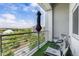 Cozy condo balcony with umbrella, chairs, turf, and views of the surrounding park and nearby buildings at 2958 Syracuse St # 403, Denver, CO 80238