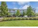 Modern condo building with lush landscaping and mature trees on a beautiful day at 2958 Syracuse St # 403, Denver, CO 80238