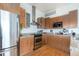 Bright kitchen showcasing stainless steel appliances, granite countertops and wood flooring at 2958 Syracuse St # 403, Denver, CO 80238