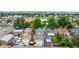 An aerial view shows a neighborhood with single Gathering homes, trees, and a clear view of the city in the background at 2676 S Lincoln St, Denver, CO 80210