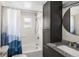 Bathroom features a shower-tub combo, tile surround, modern vanity, and neutral decor at 2676 S Lincoln St, Denver, CO 80210