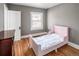 Small bedroom with a window, hardwood floors, and a simple bed frame at 2676 S Lincoln St, Denver, CO 80210