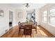 Bright dining room with a round table, hardwood floors, and a view into the kitchen and bedroom at 2676 S Lincoln St, Denver, CO 80210
