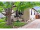 Inviting home with a black-framed porch, a mature shade tree, and green grass at 2676 S Lincoln St, Denver, CO 80210