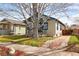 Charming bungalow with wrought iron porch railing, stucco siding, and black trim on a landscaped lot at 2676 S Lincoln St, Denver, CO 80210