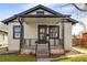 Charming bungalow with wrought iron porch railing, stucco siding, and black trim on a landscaped lot at 2676 S Lincoln St, Denver, CO 80210