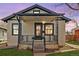 Charming home featuring an inviting front porch with decorative wrought iron railings and a well-maintained lawn at 2676 S Lincoln St, Denver, CO 80210