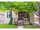 Charming bungalow featuring a covered front porch, black iron railings, and fresh landscaping at 2676 S Lincoln St, Denver, CO 80210