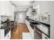 Bright kitchen with white cabinets, stainless steel appliances, and black countertops at 2676 S Lincoln St, Denver, CO 80210