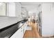 Bright kitchen features stainless steel appliances, white cabinetry, subway tile backsplash, and hardwood floors at 2676 S Lincoln St, Denver, CO 80210