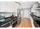 White kitchen featuring stainless appliances, white subway tile and view of backyard at 2676 S Lincoln St, Denver, CO 80210
