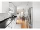 Bright kitchen featuring white cabinets, stainless steel appliances, and a view of the dining area at 2676 S Lincoln St, Denver, CO 80210