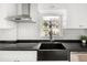 Modern kitchen sink with stainless steel faucet and white backsplash, showcasing bright natural light at 2676 S Lincoln St, Denver, CO 80210