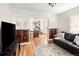Cozy living room with hardwood floors, wood trim details, and an open view to the dining area and kitchen at 2676 S Lincoln St, Denver, CO 80210