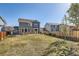 A spacious backyard with a well-maintained lawn, patio seating, and a wooden privacy fence at 20942 E Hampden Pl, Aurora, CO 80013