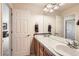 Bright bathroom with double sinks, white tile countertops, and a large mirror reflecting the doorway at 20942 E Hampden Pl, Aurora, CO 80013