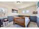Cozy bedroom with a crib, two windows and a small shelf for books and photos at 20942 E Hampden Pl, Aurora, CO 80013
