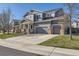 Two-story home with a three-car garage, porch, and well-maintained lawn at 20942 E Hampden Pl, Aurora, CO 80013