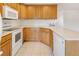 Well-lit kitchen featuring light-colored wood cabinets, white appliances, and laminate countertops at 1840 E 84Th Ave, Denver, CO 80229