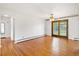 Spacious open-concept room with hardwood floors and sliding glass doors to a patio at 1840 E 84Th Ave, Denver, CO 80229