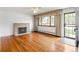 Bright living room featuring hardwood floors, a cozy fireplace, and large window for ample natural light at 1840 E 84Th Ave, Denver, CO 80229