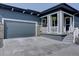 Charming home featuring a covered front porch, gray exterior, two-car garage, and stone facade at 527 Felicity Loop, Castle Rock, CO 80109