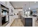 Modern kitchen featuring white cabinets, stainless steel appliances, a marble backsplash, and an island with bar seating at 527 Felicity Loop, Castle Rock, CO 80109