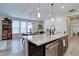 Open-concept kitchen with island seating, stainless steel appliances, and a dining area with natural light at 527 Felicity Loop, Castle Rock, CO 80109