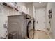 Laundry room with modern stainless steel washer and dryer with storage shelves at 527 Felicity Loop, Castle Rock, CO 80109