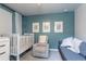 Charming Bedroom features a white crib, cozy chair, and a colorful gallery wall, creating a soothing space at 2829 W 53Rd Ave # 104, Denver, CO 80221