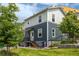 Two story townhome with blue and green siding, stairs to the entry, and landscaped yard at 2829 W 53Rd Ave # 104, Denver, CO 80221