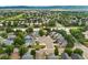 An aerial view reveals a neighborhood with varied home styles nestled within a green, tree-filled landscape at 10294 Spotted Owl Ct, Highlands Ranch, CO 80129