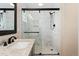 Modern bathroom featuring marble tile shower with black hardware and glass doors, plus stone countertop vanity at 10294 Spotted Owl Ct, Highlands Ranch, CO 80129