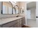 Bathroom with gray vanity with stone countertop and decorative mirrors, with access to the bedroom at 10294 Spotted Owl Ct, Highlands Ranch, CO 80129