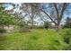 Spacious backyard surrounded by mature trees, well-maintained lawn, and wooden fence at 3285 Balsam St, Wheat Ridge, CO 80033